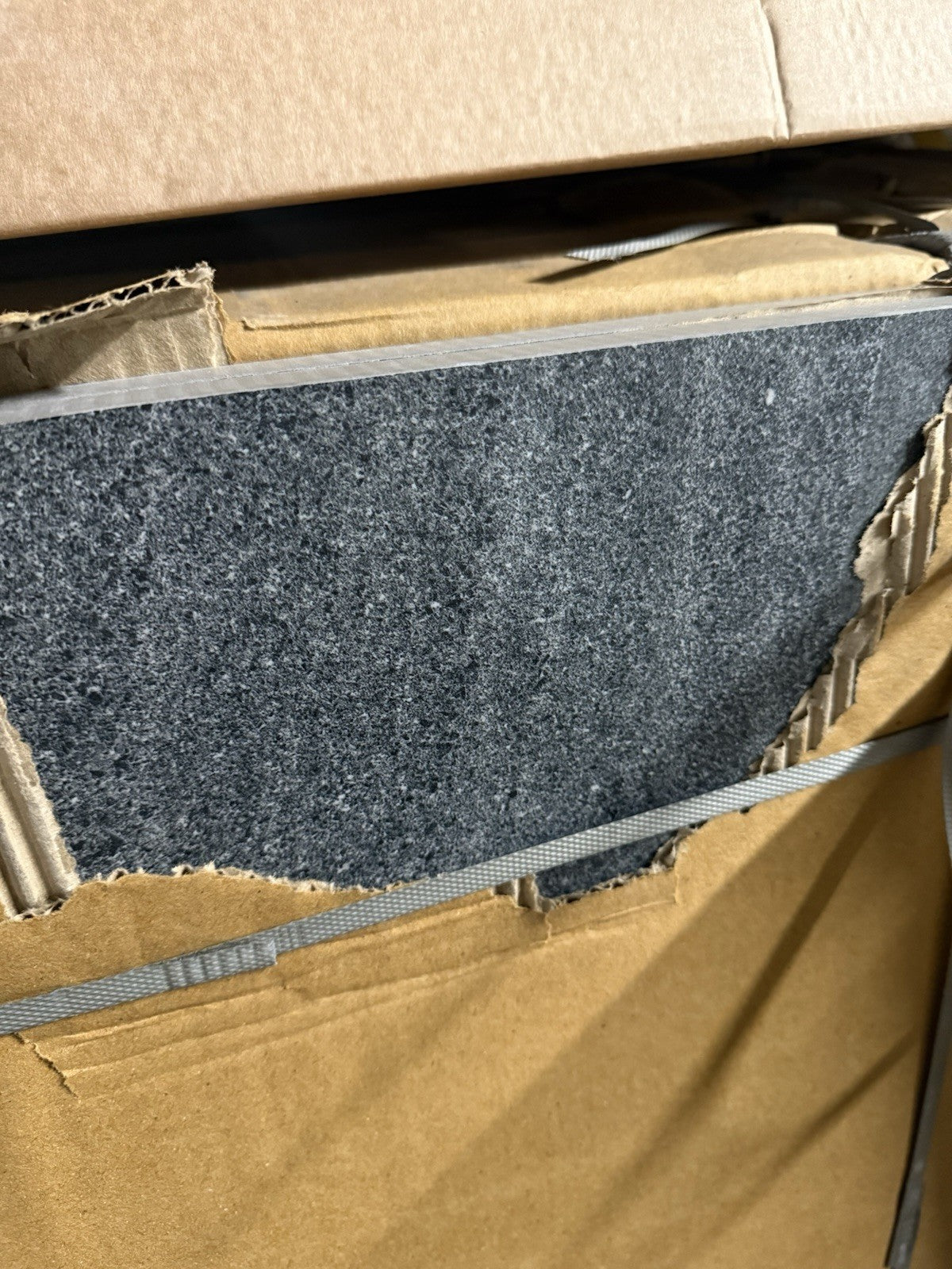 Close-up of black outdoor porcelain floor tiles displayed in packaging by Ironbridge & Sons Ltd