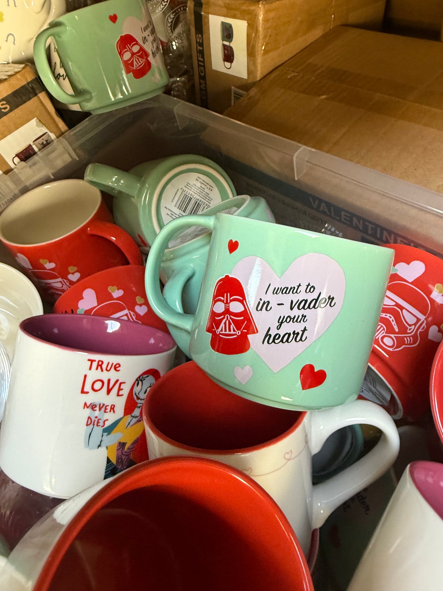 Wholesale pallet of colorful seasonal mugs featuring fun designs and Valentine's themes