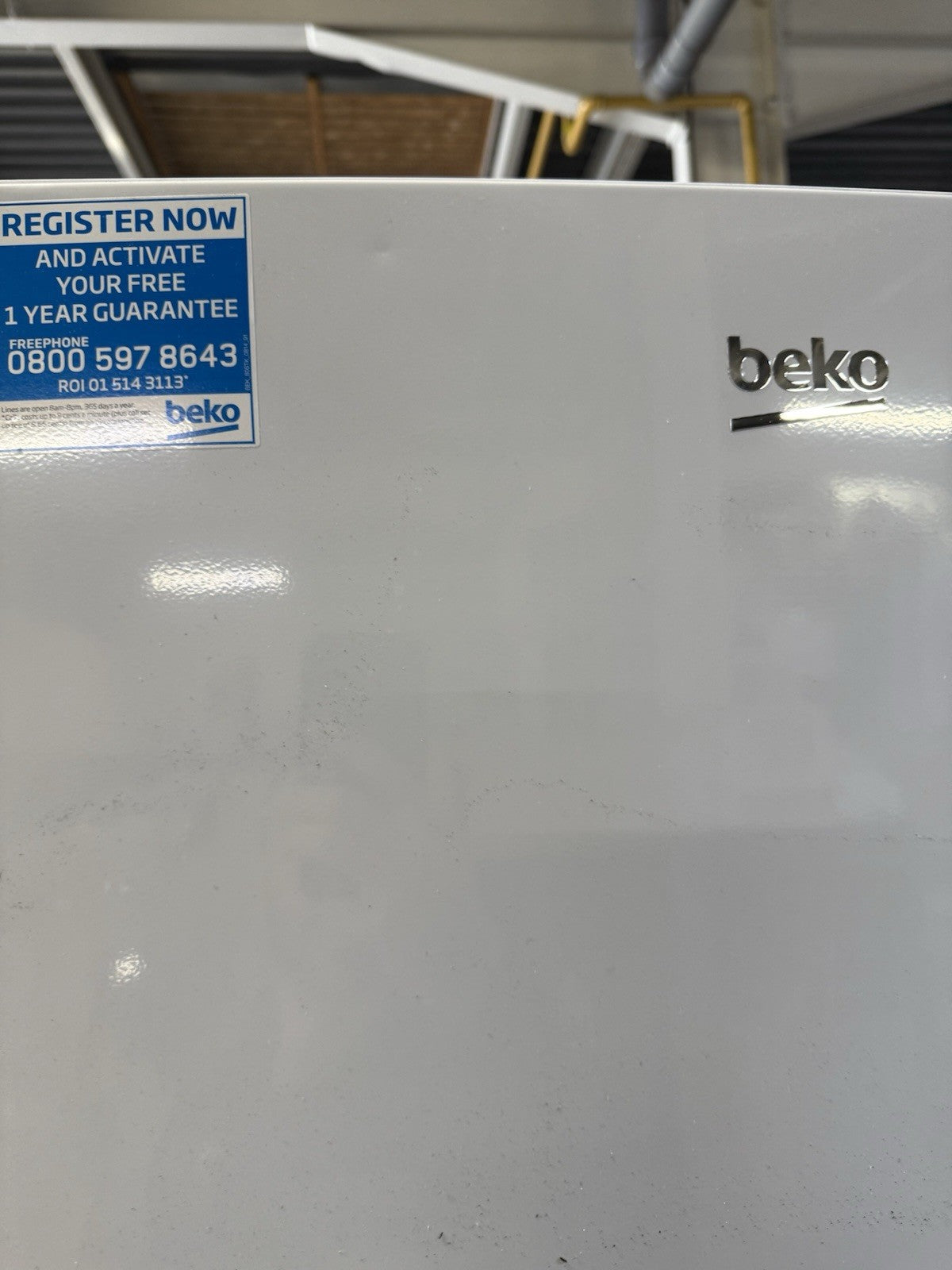 Beko CFG4582W frost free fridge freezer with a sleek design and registration instructions on the front