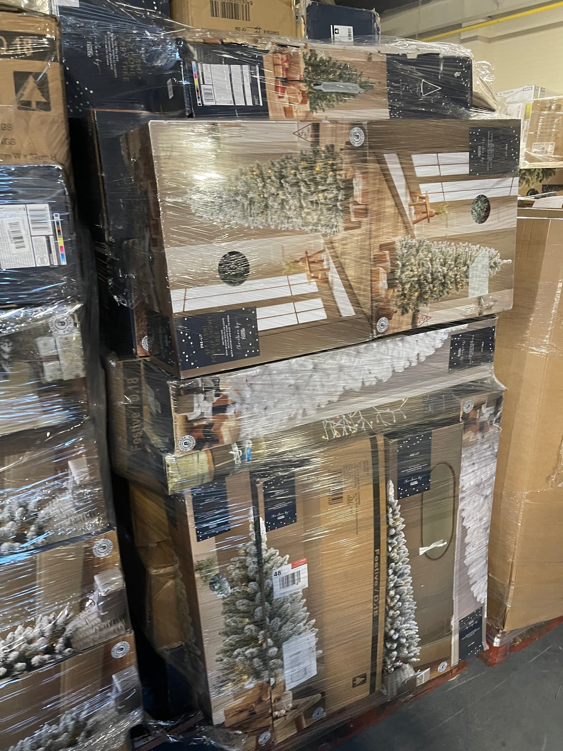 Stacked boxes of wholesale Christmas tree pallets ready for distribution in a warehouse