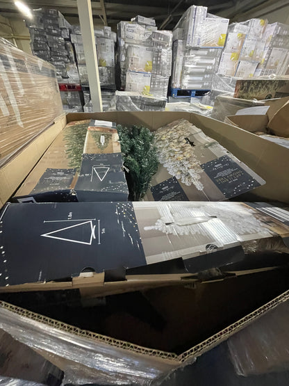 Wholesale Christmas tree pallets containing assorted holiday decorations and tree components stacked in a warehouse